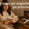 Realistyczna fotografia przedstawiająca młodą kobietę siedzącą w miękkim fotelu, przykrytą ciepłym kocem. Kobieta czyta książkę po angielsku, a obok niej, na stoliku, leżą inne angielskie książki z kolorowymi ilustracjami i tytułami w oryginale. Scenę oświetla miękkie, jesienne światło, które tworzy przytulny nastrój. Obrazek ilustruje temat czytanie po angielsku po przerwie.