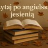 Używane książki po angielsku leżące na drewnianym stole wśród suchych liści, z otwartą książką na szczycie stosu i napisem „Czytaj po angielsku jesienią” w tle.